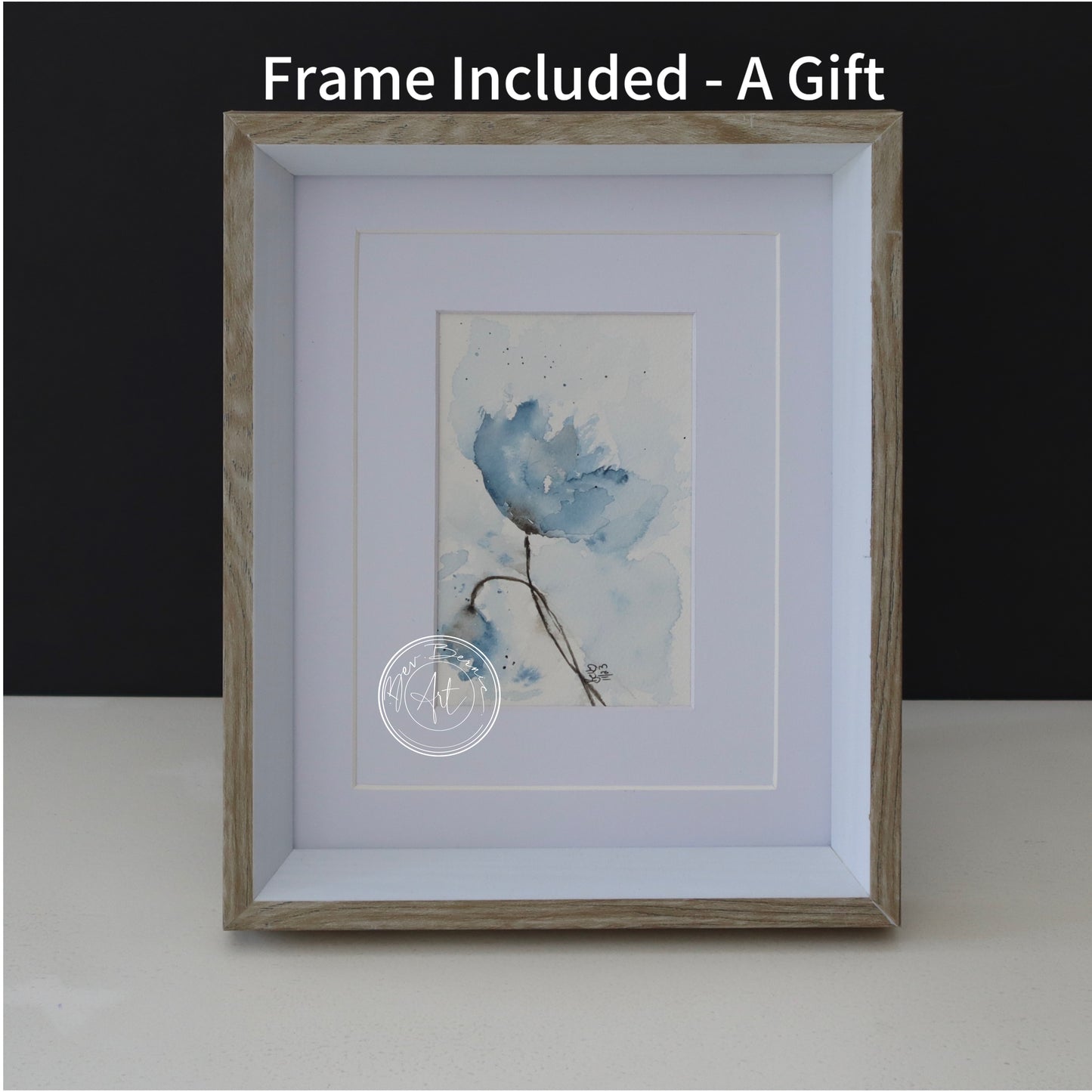 Minimalist watercolour of a blue flower with soft washes of colour, matted in white and framed in a light wood frame.