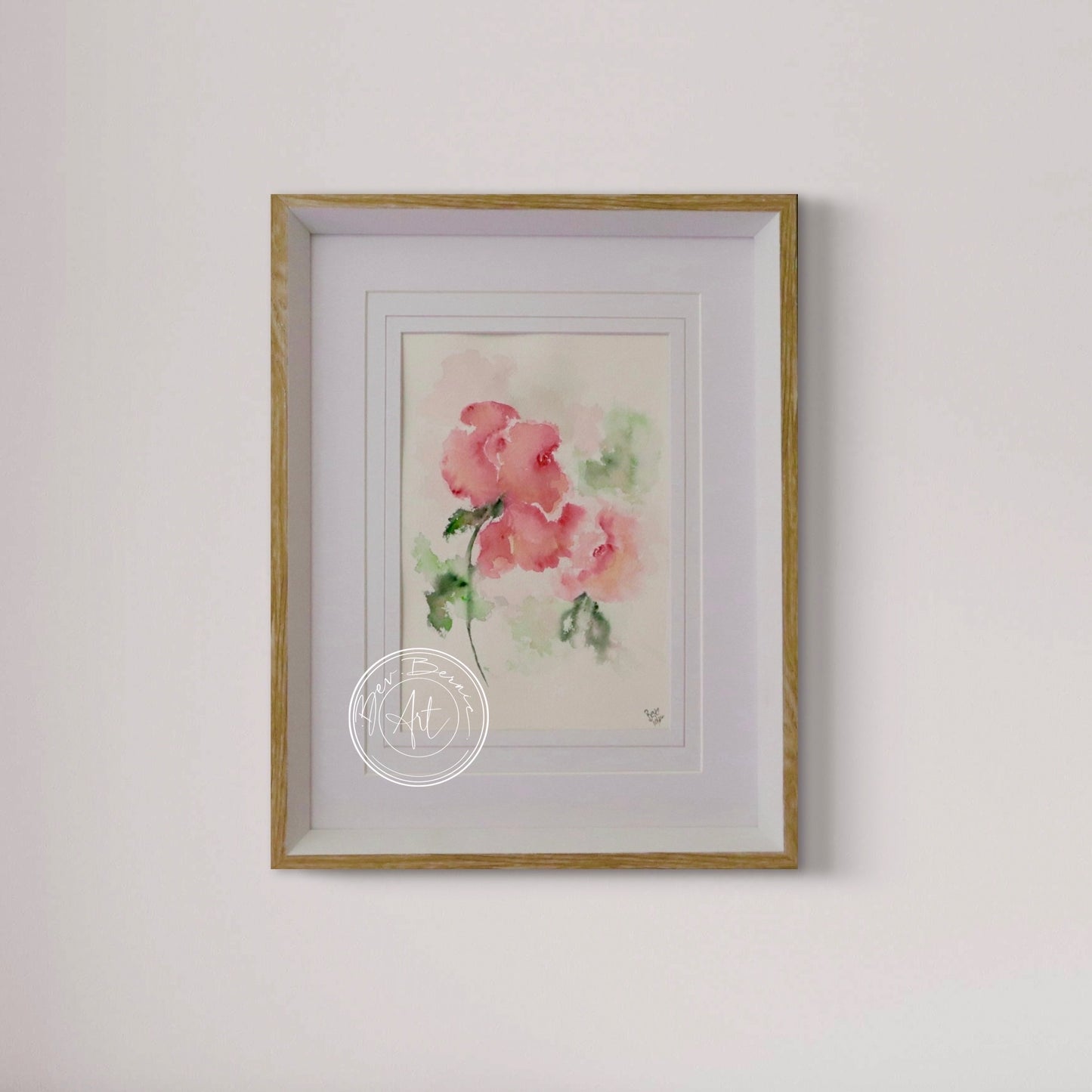 Framed watercolor painting of pink flowers on a white wall