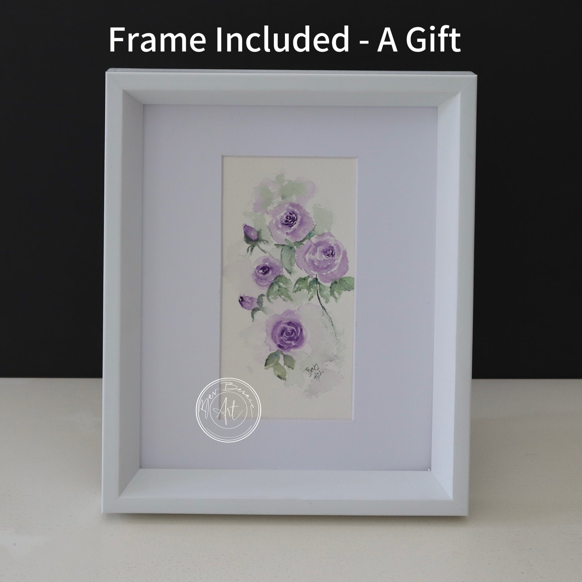 Watercolour painting of several purple roses with green leaves on a textured, off-white background, framed in a white frame with a white mat.