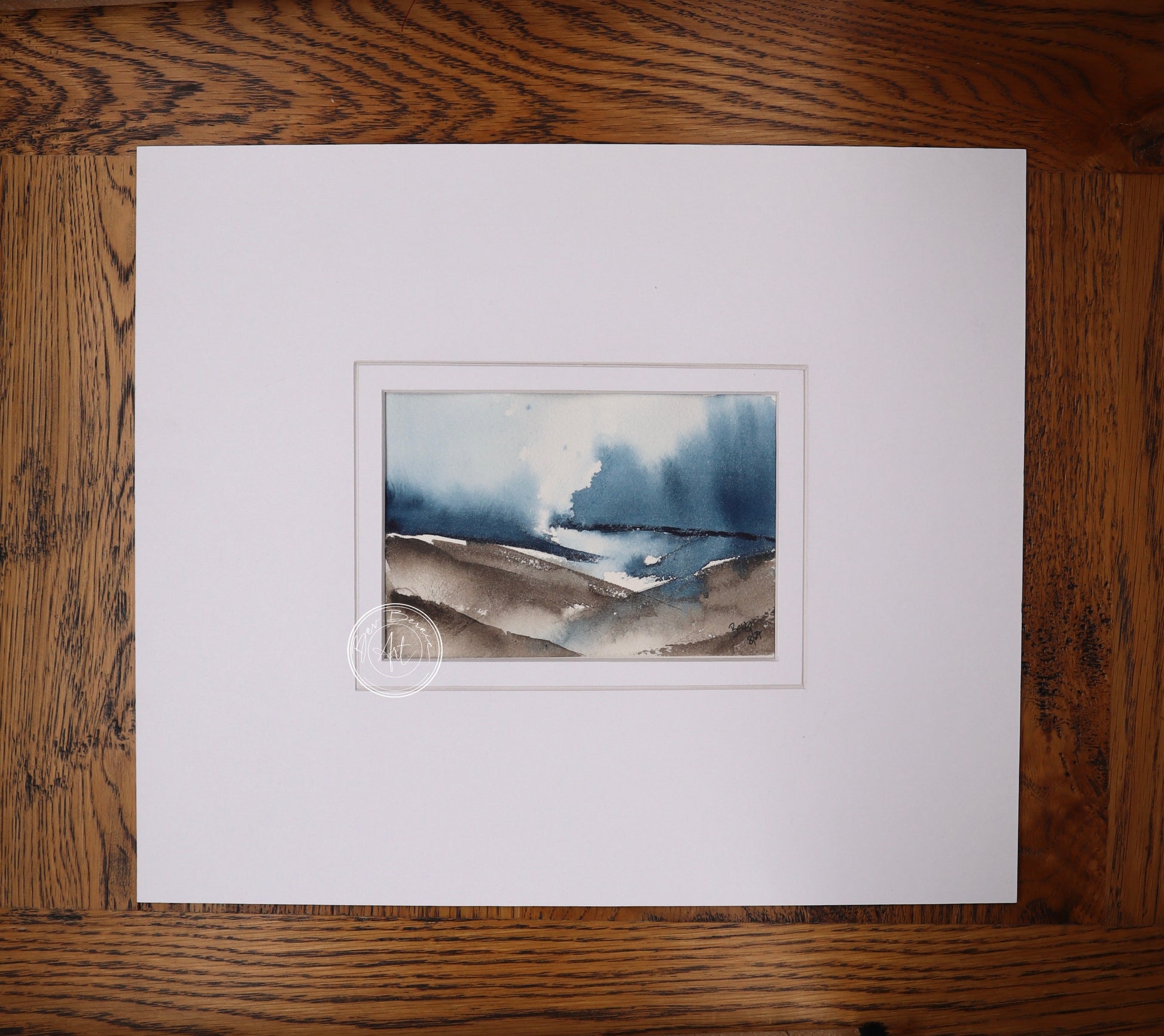 Main view of Misty Highlands No. 1, a watercolour painting featuring indigo skies and sepia-toned rolling hills, mounted in a white mat.