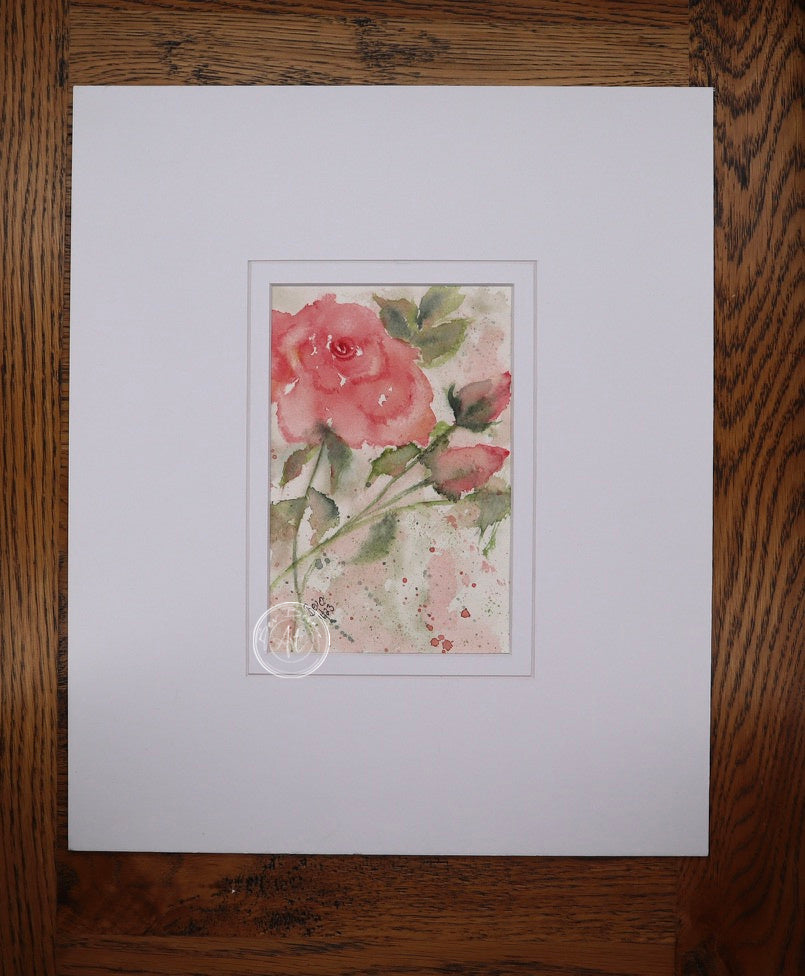 Main view of New Beginnings, featuring a delicate pink rose and buds painted in watercolour, mounted in a white mat.