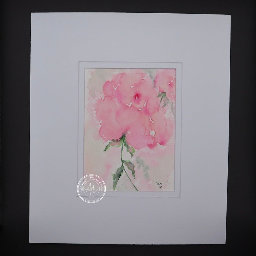 Main view of Soft Bloom, featuring a delicate soft pink flower painted in watercolour, mounted in a white mat.