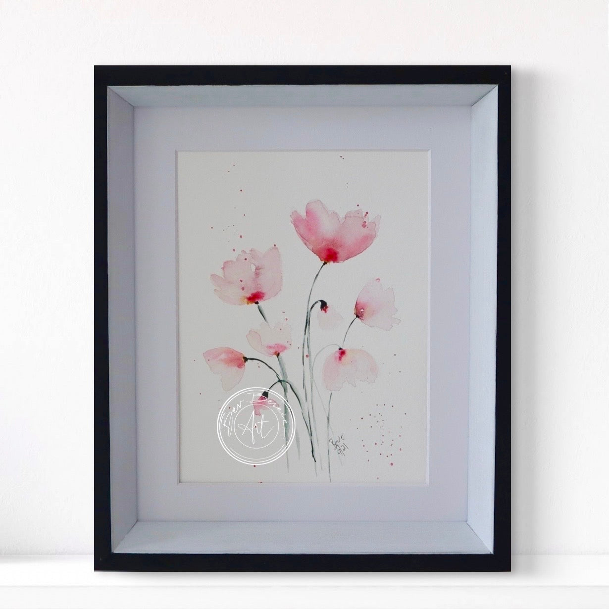 Framed artwork of pink flowers on a white background