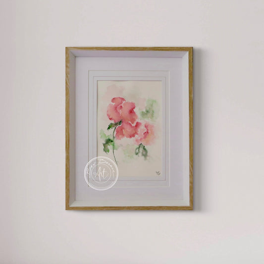 Framed watercolor painting of pink flowers on a white wall