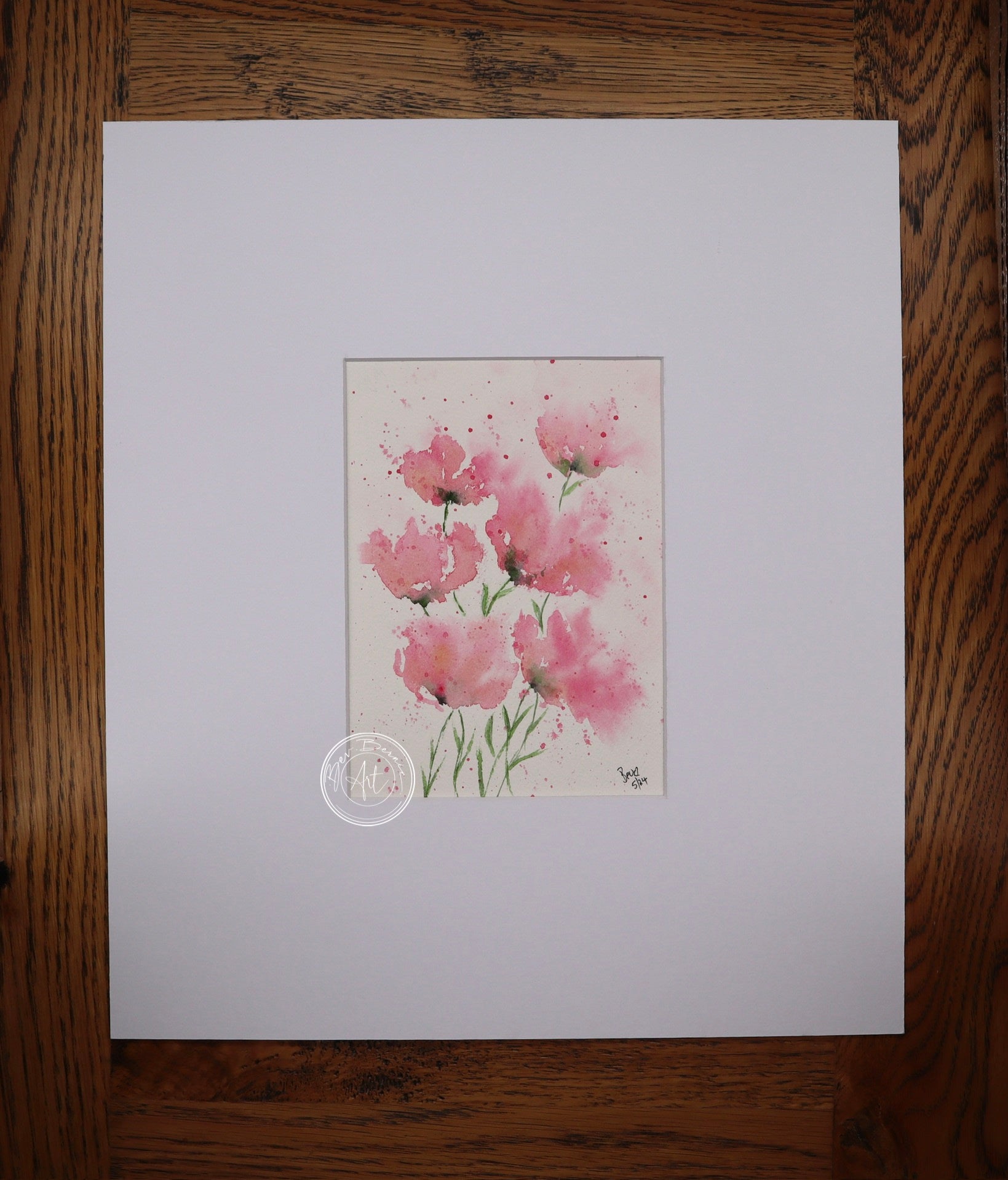 Watercolour painting of five pink poppies with delicate green stems, splattered with pink paint on a white background.