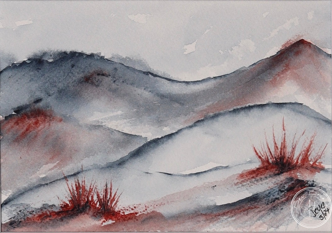 Watercolour painting of a rolling landscape with blue-grey hills and splashes of red, possibly representing desert shrubs, in the foreground.
